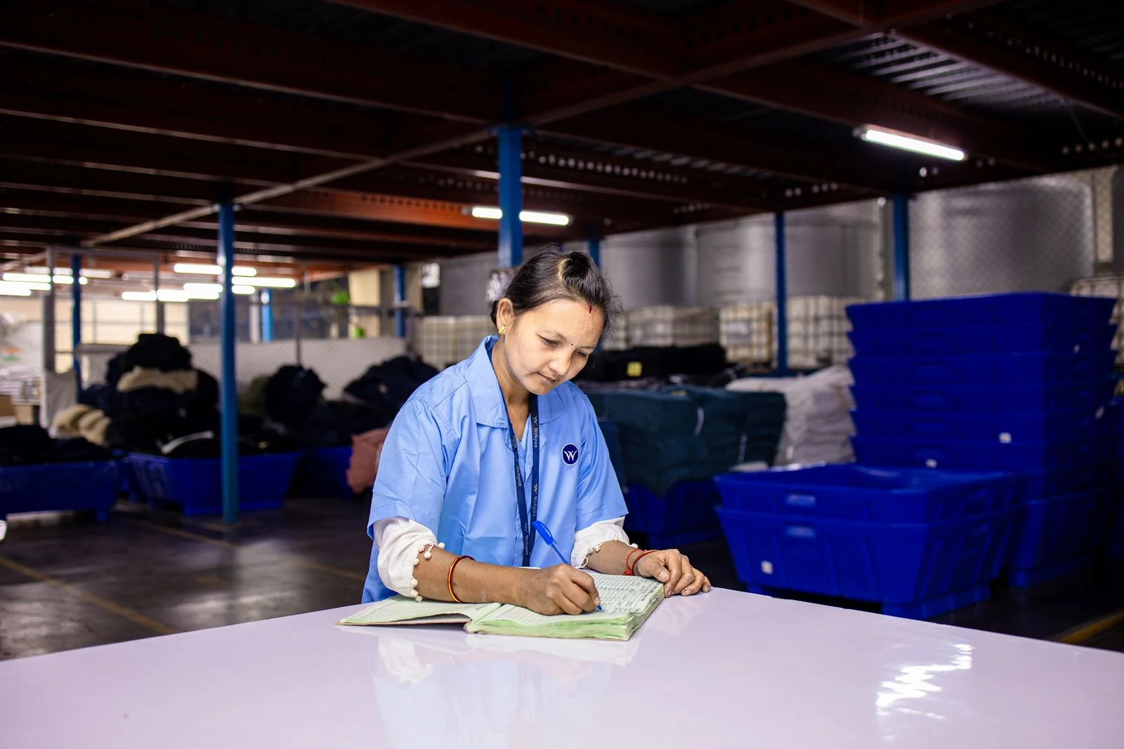 An industrial operator recording checks on a worksheet
