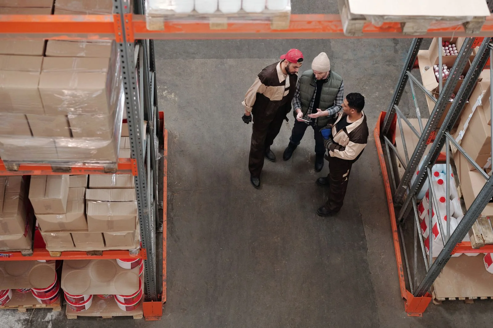 Three warehouse colleagues discussing information on a tablet